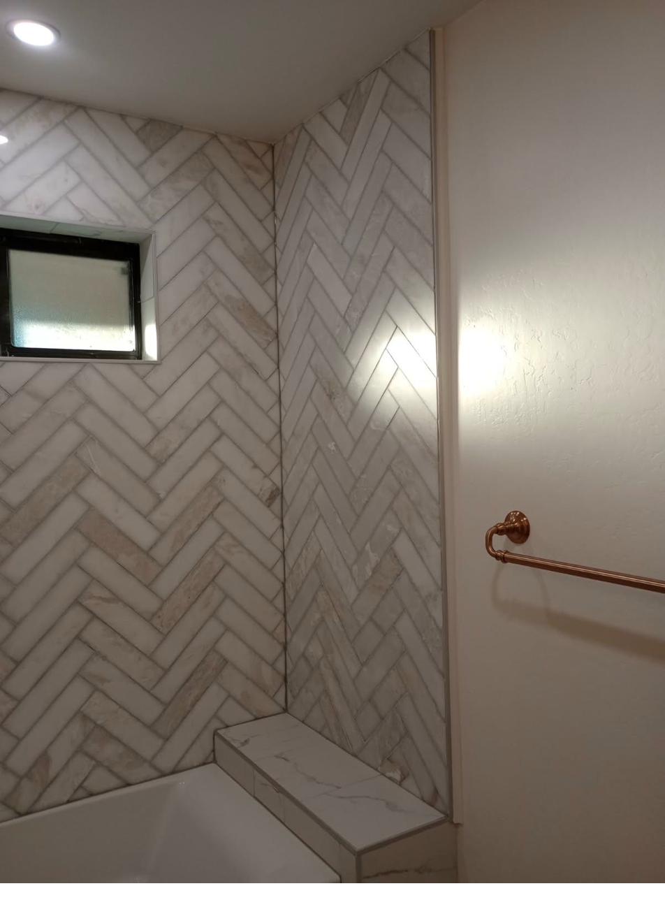 Herringbone tile with gold towel bar