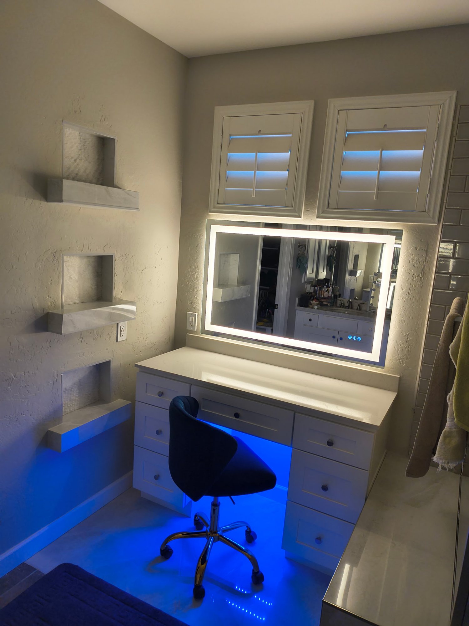 Makeup vanity with LED backlit mirror and marble niche shelves